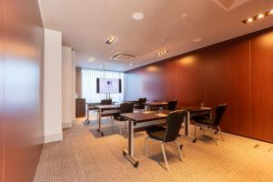 a conference room with tables and chairs and a screen at DoubleTree by Hilton Hotel Newcastle International Airport in Newcastle upon Tyne