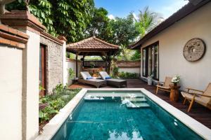 a swimming pool in the backyard of a house at Svarga Bebek Villas in Ubud