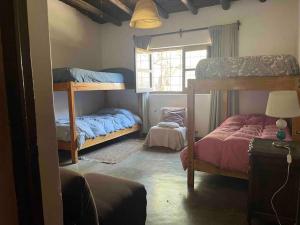 1 dormitorio con 2 literas y ventana en Posada La Escondida en San Carlos