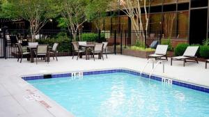 einen Pool mit Stühlen, einem Tisch und einer Terrasse in der Unterkunft Hilton Greenville in Greenville
