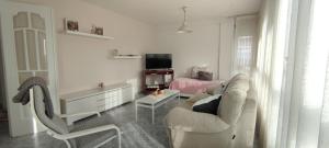 a white living room with a couch and a chair at Xabarin Apartment in Abadín