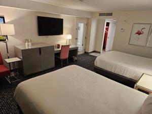 a hotel room with two beds and a desk at Attractive Modern Unit by Flamingo Strip Las Vegas in Las Vegas