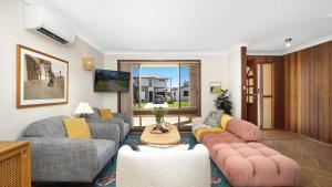 Una sala de estar con dos sofás y una mesa. en Sylvia's at Currarong, en Currarong