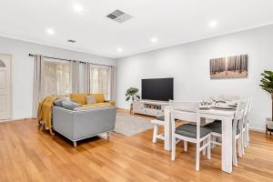 ein Wohnzimmer mit Tisch und Couch und ein Esszimmer in der Unterkunft Brompton Bliss - A Relaxed Northern Adelaide Retreat in Adelaide