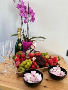 a table topped with bowls of fruit and a bottle of wine at Chalet détente proche plage in La Ciotat