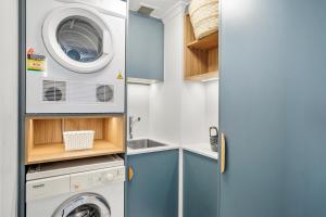 a small laundry room with a washer and dryer at Belle Escapes Oceanview Suite 11 Alamanda Palm Cove in Palm Cove
