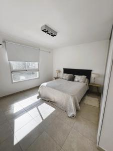 a white bedroom with a bed and a window at Departamento en pleno centro de Corrientes in Corrientes