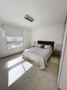 una camera da letto bianca con un letto e una finestra di Departamento en pleno centro de Corrientes a Corrientes