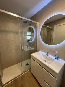 uma casa de banho com um lavatório e um chuveiro com um espelho. em Hany apartment Ducado 7-C em Benidorm
