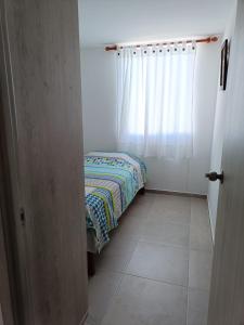 een kleine kamer met een bed en een raam bij Apartamento completo 3 habitaciones in Neiva