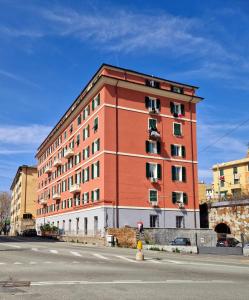 un grand bâtiment rouge sur le côté d'une rue dans l'établissement Appartamento Sofia a Genova, à Gênes