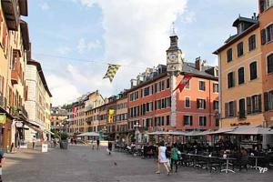 a city street with a clock tower and people walking at Moonlight in Chambéry