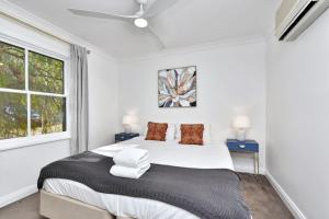 Un dormitorio con una cama grande y dos ventanas. en Villa 3br Bella Vista Villa located within Cypress Lakes Resort, en Pokolbin 27 fotos más