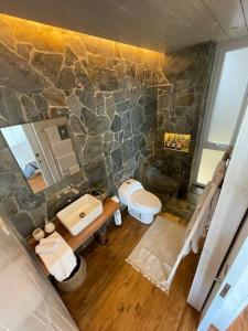uma casa de banho com 2 lavatórios e uma parede de pedra em Espectacular Loft, a pasos del mar em Curanipe