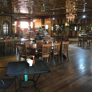 a restaurant with wooden floors and tables and chairs at Tropical Magnolia 