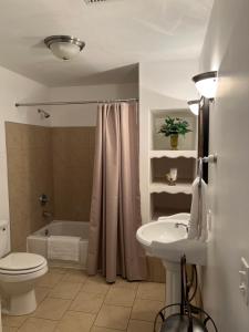 een badkamer met een toilet, een wastafel en een bad bij Eagles Nest Inn in Louisiana