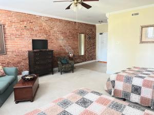 een woonkamer met een bed en een bakstenen muur bij Eagles Nest Inn in Louisiana