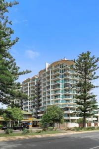 a large apartment building on the side of a street at Warm Waves - Beach Pool Home in Glenelg