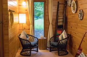 2 sillas y una mesa en una habitación con ventana en Krishna Farm Retreat en Coolabine