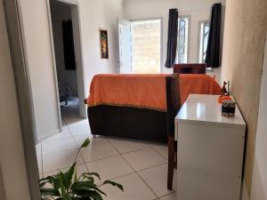 a bedroom with a bed with a orange blanket on it at Lugarzin2 - Casa Privada - Garagem Compartilhada in Vitória da Conquista