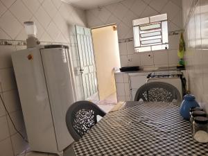 uma cozinha com uma mesa e um frigorífico branco em Lugarzin2 - Casa Privada - Garagem Compartilhada em Vitória da Conquista