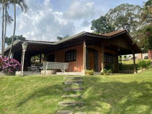 a house with a bench in a yard at sitio dona cida e joze in Extrema