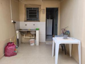 a small kitchen with a table and a refrigerator at Lugarzin2 - Casa Privada - Garagem Compartilhada in Vitória da Conquista