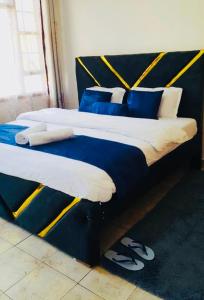 two beds with blue and white pillows on them at Kisumu 3 bedroom Apartment Elegant in Kisumu