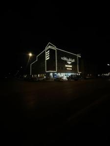 a large building with a sign on it at night at الرياض بارك للاجنحة الفندقية in Riyadh