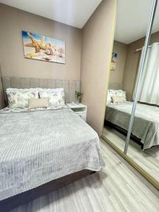 um quarto com uma cama e um espelho em RJ Residencial Beira Mar Maravilhosa Casa Frente Mar da Pinheira com piscina em Pinheira