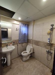un baño con inodoro y lavabo en Comfortia Guest House 2 Bed DringDining, en Karachi
