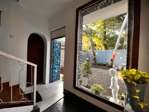 a room with a window with a statue in it at The Lovina Place in Mount Lavinia