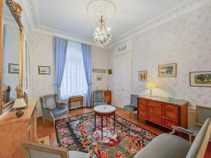 a living room with a table and chairs and a chandelier at Demeure d'exception dans vaste domaine in Quintin