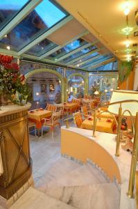 - un restaurant avec des tables et des chaises dans une salle dans l'établissement Boutique-Hotel Bauer, à Saalbach-Hinterglemm