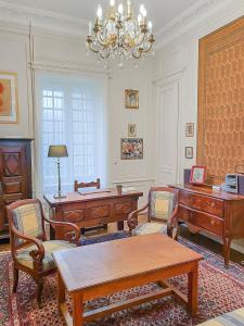 un salon avec un bureau, une table et un lustre dans l'établissement Demeure d'exception dans vaste domaine, à Quintin