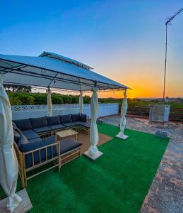 un patio con una sombrilla y sillas azules y una mesa en Villa Caliqueña, casa de campo, en Torrent