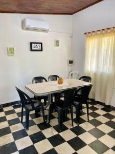 ein Esszimmer mit einem Tisch und Stühlen auf einem karierten Boden in der Unterkunft Los Cardenales in San José + 17 Fotos