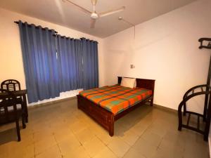 a bedroom with a bed and two chairs and a window at The Lovina Place in Mount Lavinia