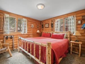 - une chambre avec un lit dans une pièce dotée de murs en bois dans l'établissement Lake Flora Cabin, à Leadville