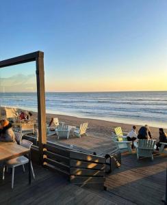 a group of people sitting in chairs on the beach at Casa en cerro, playa, piscina y vista insuperable in El Convento