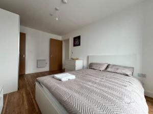 1 dormitorio con 1 cama grande en una habitación blanca en 19th floor 2 bedroom apartment with stunning views, en Mánchester