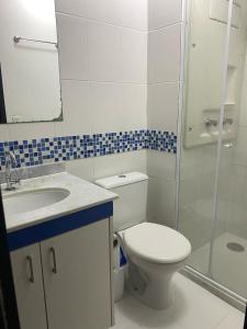 a bathroom with a toilet and a sink and a shower at Apartamento Aconchegante in Porto Alegre