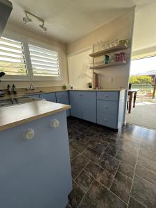 a kitchen with blue cabinets and a tile floor at Omara-more in Omarama