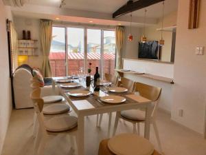 ein Esstisch mit Stühlen und ein großes Fenster in der Unterkunft VILLA TAKAYAMA in Takayama