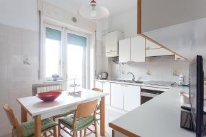 una cucina con armadi bianchi, tavolo e sedie di [Leo's House] smart Tv & Wi-Fi a Campobasso