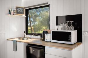a kitchen with a counter with a microwave and a sink at Bush Retreat 2 by Tiny Away in Alberton West