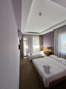 a hotel room with two beds and two windows at Lara Kapris Hotel in Antalya