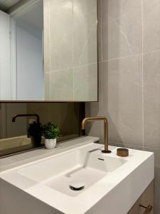 y baño con lavabo blanco y espejo. en Skygarden Luxury Condo, en Glen Waverley