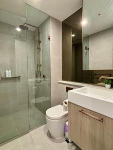 a bathroom with a shower and a toilet and a sink at Skygarden Luxury Condo in Glen Waverley