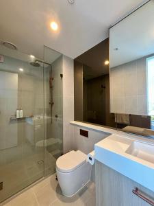 a bathroom with a toilet and a sink and a shower at Skygarden Luxury Condo in Glen Waverley